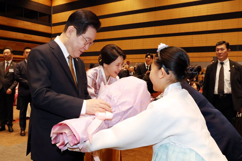 [나라=뉴시스] 고범준 기자 = 이재명 대통령과 김혜경 여사가 14일(현지 시간) 일본 나라현의 한 호텔에서 열린 간사이 동포 간담회에서 화동들에게 꽃다발을 받고 있다. 2026.01.14. bjko@mewsis.com