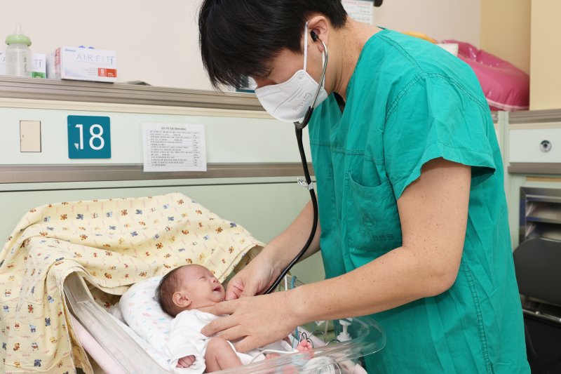 [서울=뉴시스] 서울아산병원은 심장 크기가 엄지손가락만한 저체중아의 복잡한 선천성심장병을 생후 8일 만에 치료하는 데 성공했다. 사진은 정의석 서울아산병원 신생아과 교수가 지난 2일 수술 후 신생아 중환자실에서 집중치료를 받고 있는 이준이를 진찰하고 있는 모습. (사진= 서울아산병원 제공)