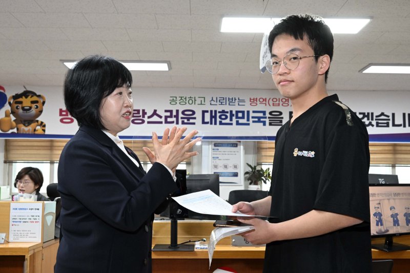 홍소영 병무청장이 15일 오전 서울 영등포구 서울지방병무청 제1병역판정검사장에서 열린 2026년도 병역판정검사에서 첫 현역 판정자를 축하해주고 있다. 공동취재단