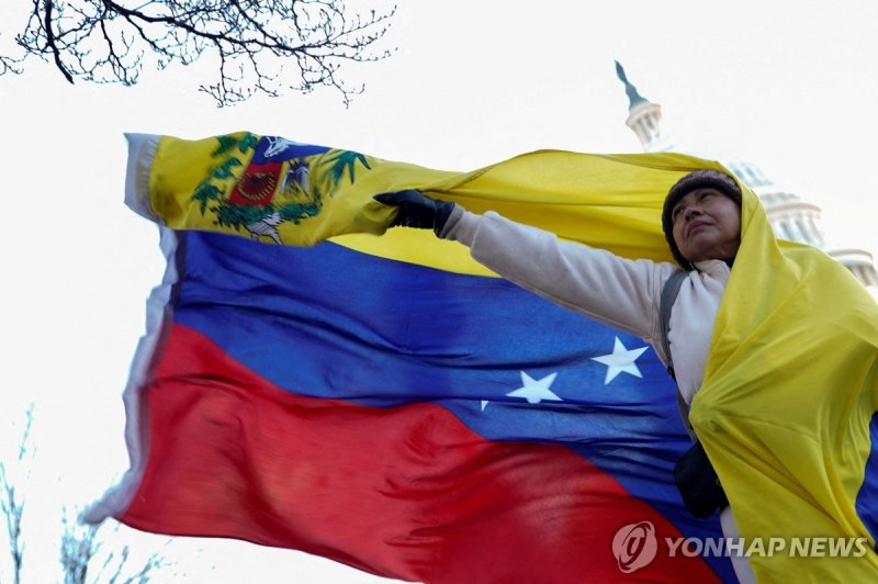15일(현지시간) 미국 국회의사당 앞에서 베네수엘라 국기 펼치는 여성 (출처=연합뉴스)