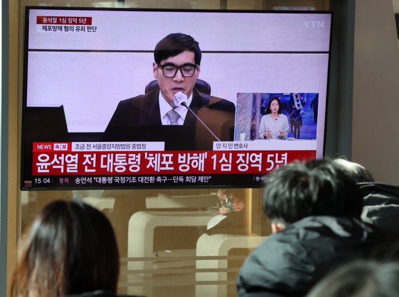 [서울=뉴시스] 배훈식 기자 = 윤석열 전 대통령의 첫 선고 재판이 열린 16일 오후 서울 용산구 서울역 대합실에서 시민들이 재판 생중계를 보고 있다. 서울중앙지법 형사합의35부(부장판사 백대현)는 이날 특수공무집행방해 등의 혐의로 기소된 윤 전 대통령에게 징역 5년을 선고 했다. 2026.01.16. dahora83@newsis.com