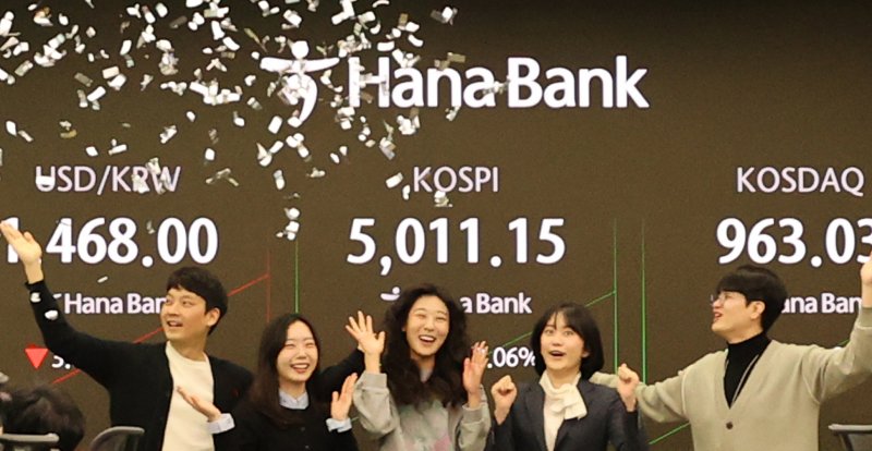 [서울=뉴시스] 22일 오전 서울 중구 하나은행 딜링룸에서 딜러들이 코스피 5000 돌파를 기뻐하고 있다. (사진=하나은행 제공) 2026.01.22. photo@newsis.com *재판매 및 DB 금지