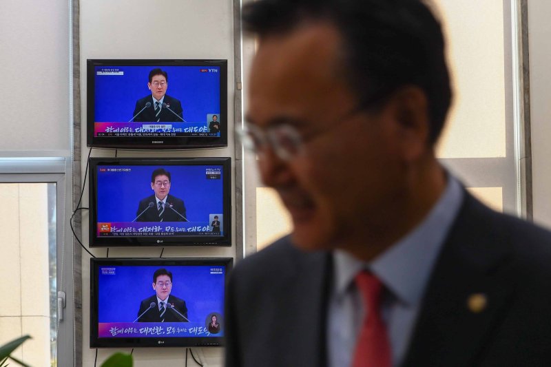 [서울=뉴시스] 김명년 기자 = 21일 오전 서울 여의도 국회 국민의힘 원내대표실에서 유상범 원내운영수석부대표 뒤로 이재명 대통령 신년 기자회견 장면이 화면에 나오고 있다. 2026.01.21. kmn@newsis.com