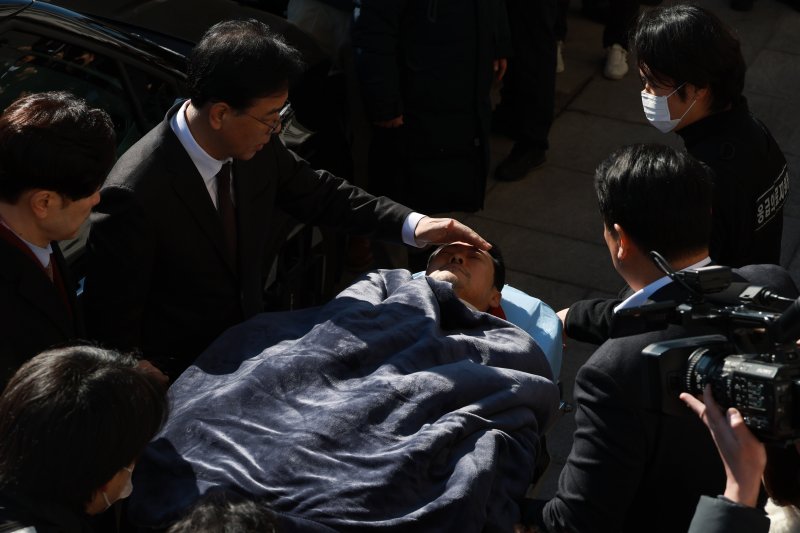 [서울=뉴시스] 고승민 기자 = 여드레째 단식농성을 이어 온 장동혁 국민의힘 대표가 22일 서울 여의도 국회에서 병원으로 이송되고 있다. 송언석 원내대표 등이 햇빛을 가려주고 있다. 2026.01.22. kkssmm99@newsis.com