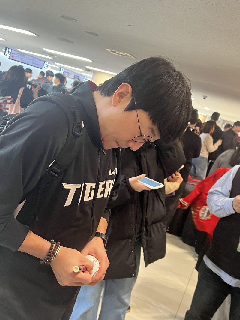 KIA 타이거즈 투수 양현종이 23일 김포공항에서 팬들을 위해 야구공에 사인하고 있다. 2026.1.23/뉴스1 ⓒ News1 이상철 기자