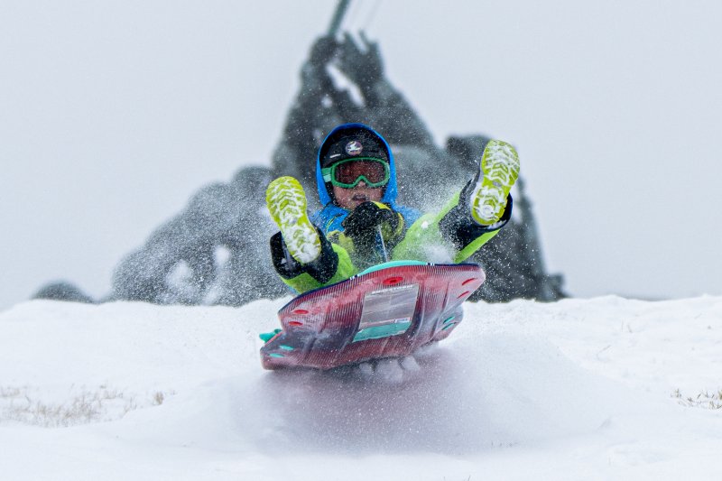 [알링턴=AP/뉴시스] 25일(현지 시간) 미 버지니아주 알링턴에 눈이 내리는 가운데 한 소년이 미 해병대 전쟁 기념비 앞에서 눈썰매를 타고 있다. 강력한 눈 폭풍이 미 남부에서 북동부로 이동하면서 폭설과 결빙으로 인한 대규모 정전 사태와 항공편 결항 등 피해가 속출하고 있다. 2026.01.26.
