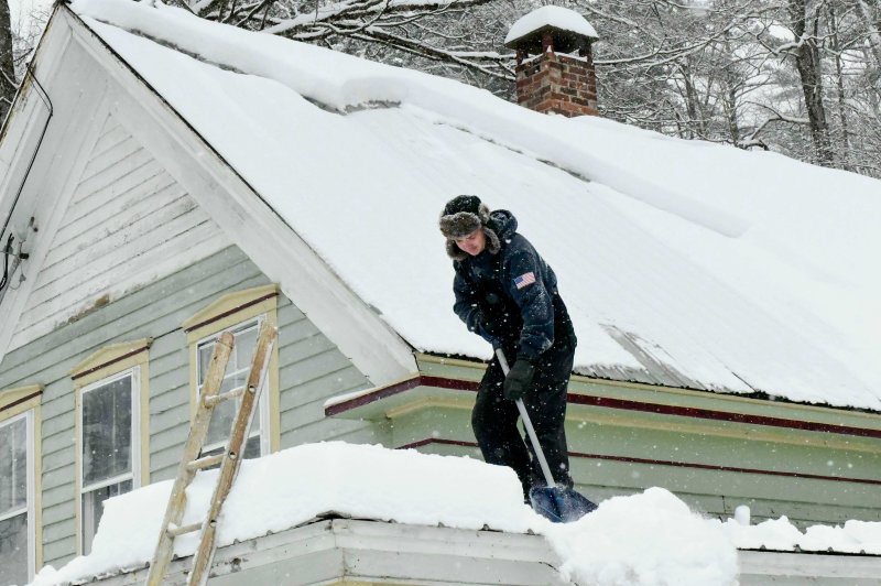 [워즈버러=AP/뉴시스] 26일(현지 시간) 미 버몬트주 워즈버러에서 한 주민이 겨울 폭풍으로 수십 센티미터 눈이 내린 뒤 건물 피해를 막기 위해 지붕의 눈을 치우고 있다. 2026.01.27.
