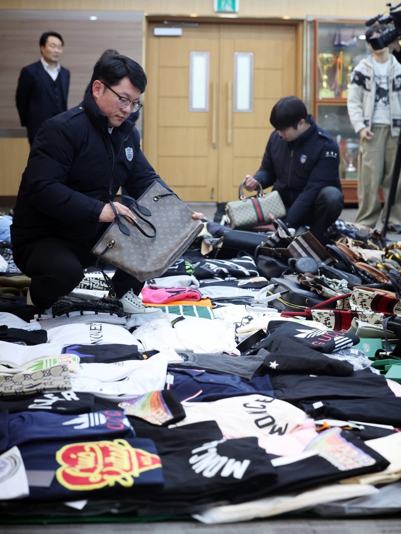 27일 오전 인천 중구 인천본부세관에서 열린 '1200억원대 위조 명품 판매 쇼핑몰 운영조직 적발' 브리핑에서 직원들이 압수품을 살펴보고 있다. 2026.1.27/뉴스1 ⓒ News1 황기선 기자