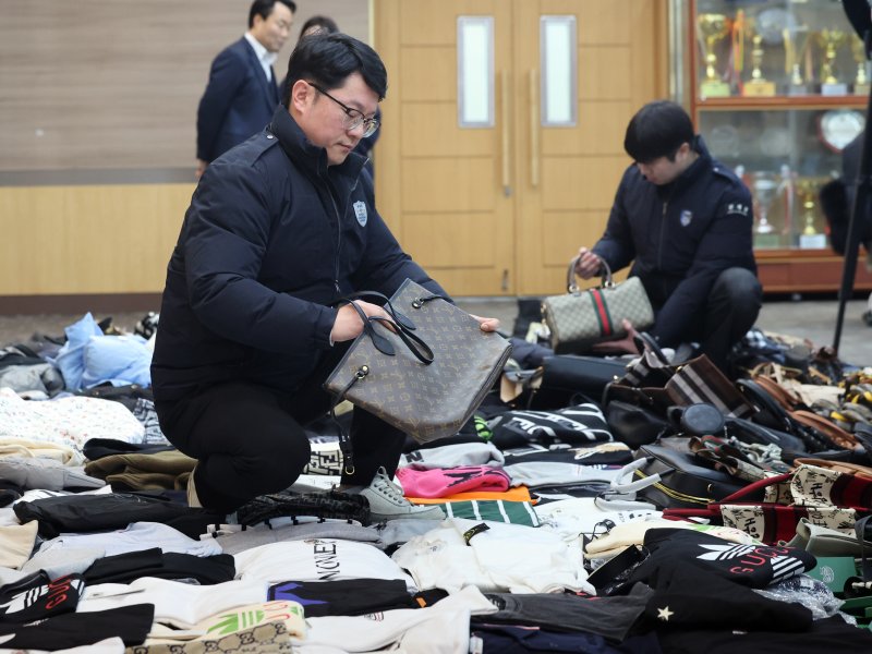 27일 오전 인천 중구 인천본부세관에서 열린 '1200억원대 위조 명품 판매 쇼핑몰 운영조직 적발' 브리핑에서 직원들이 압수품을 살펴보고 있다. 2026.1.27/뉴스1 ⓒ News1 황기선 기자
