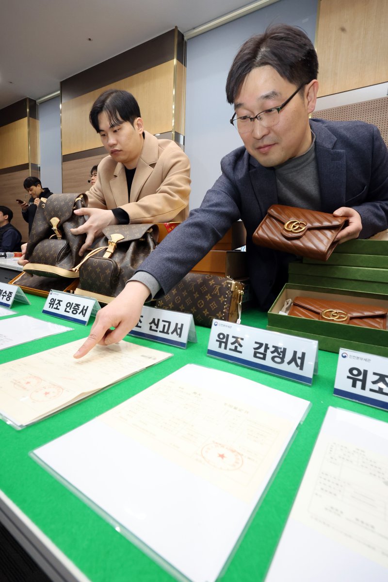 27일 오전 인천 중구 인천본부세관에서 열린 '1200억원대 위조 명품 판매 쇼핑몰 운영조직 적발' 브리핑에서 직원들이 압수품을 살펴보고 있다. 2026.1.27/뉴스1 ⓒ News1 황기선 기자