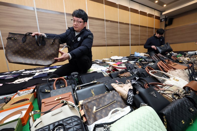 27일 오전 인천 중구 인천본부세관에서 열린 '1200억원대 위조 명품 판매 쇼핑몰 운영조직 적발' 브리핑에서 직원들이 압수품을 살펴보고 있다. 2026.1.27/뉴스1 ⓒ News1 황기선 기자