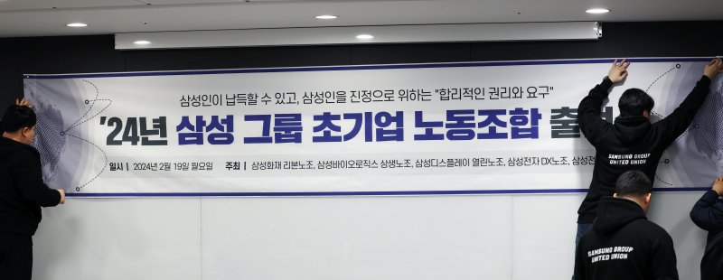 [서울=뉴시스] 고승민 기자 = 19일 서울 서초구 한국컨퍼런스센터에서 삼성그룹 초기업 노조 출범 기자회견이 열리기 전 참석자들이 기자회견 현수막을 걸고 있다. 2024.02.19. kkssmm99@newsis.com