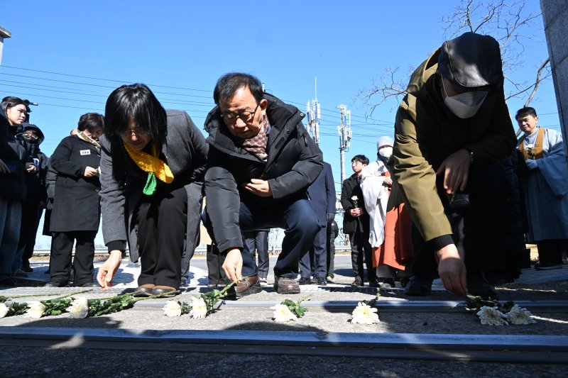 [광주=뉴시스] 이현행 기자 = 4명의 노동자가 숨진 광주대표도서관 붕괴 참사 49일을 맞아 28일 오전 광주 서구 치평동 광주대표도서관 사고 현장에서 '참사 49일 노동자 추모제'가 열린 가운데 참석자들이 사고현장 앞에서 헌화하고 있다. 2026.01.28. photo@newsis.com