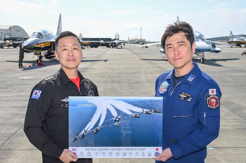 공군 특수비행팀 블랙이글스가 28일 오전, 사우디에서 열리는 국제 방위산업 전시회(WDS)에 참가하기 위해 원주기지를 출발했다. 한일 특수비행팀 간 교류행사를 실시하고 기념촬영하고 있다. 왼쪽부터 서동혁 제239특수비행대대장(중령), 에지리 스구루(江尻 卓) 이등공좌(한국군의 중령에 해당). 공군 제공