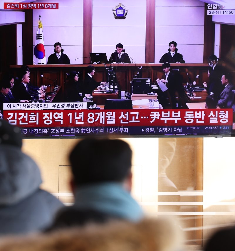 28일 오후 서울역 대합실에서 시민들이 김건희 여사의 자본시장법·정치자금법 위반, 특정범죄 가중처벌법상 알선수재 혐의 1심 선고 공판 생중계를 지켜보고 있다. 서울중앙지법 형사합의27부(부장판사 우인성)는 이날 알선수재 등 혐의로 기소된 김 여사에게 징역 1년 8개월을 선고했다. 압수된 그라프사 다이아몬드 목걸이의 몰수 및 1281만 원의 추징도 명했다. 자본시장법 위반과 정치자금법 위반 혐의에 대해서는 무죄를 선고했다. 2026.1.28/뉴스1 ⓒ News1 오대일 기자