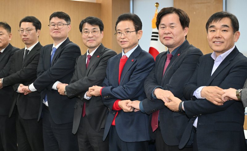 이철우 경북지사와 김정기 대구시장 권한대행(행정부시장)을 비롯한 대구·경북 관계자들이 지난 20일 오후 경북 안동시 경북도청에서 열린 대구·경북 행정통합 추진협의 회의에서 손을 잡고 있다. 뉴스1