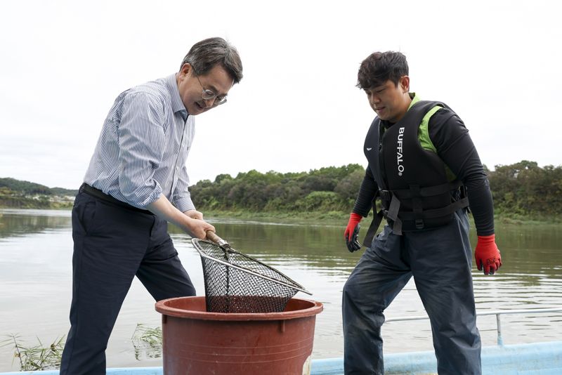 김동연 지사가 한탄강에서 청년어부와 참게를 옮기고 있다. 경기도 제공