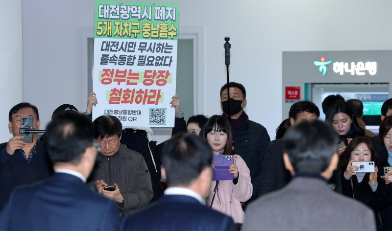 조원휘 대전시의회 의장과 홍성현 충남도의회 의장이 29일 대전시의회에서 대전·충남 행정통합 관련 공동 기자회견중 시민단체가 통합반대 피켓을 들고 있다. 2026.1.29/뉴스1 ⓒ News1 김기태 기자