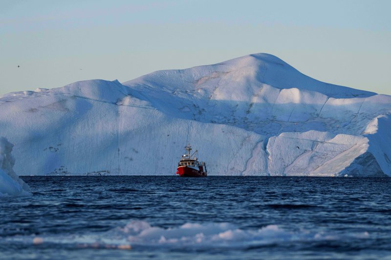 지난달 29일(현지 시간) 그린란드 일룰리사트 인근 디스코만에서 어선 한 척이 빙산 앞에서 그물을 끌어 올리며 어획한 물고기를 건지고 있다. AP·뉴시스
