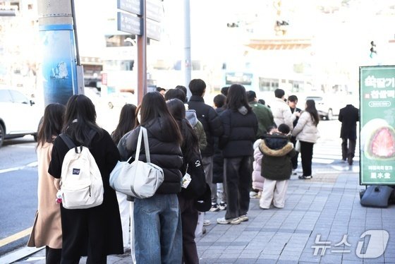 31일 추위가 누그러진 가운데 전남 여수를 찾은 방문객들이 한 상점 앞에 줄을 서 있다. 뉴스1 김성준 기