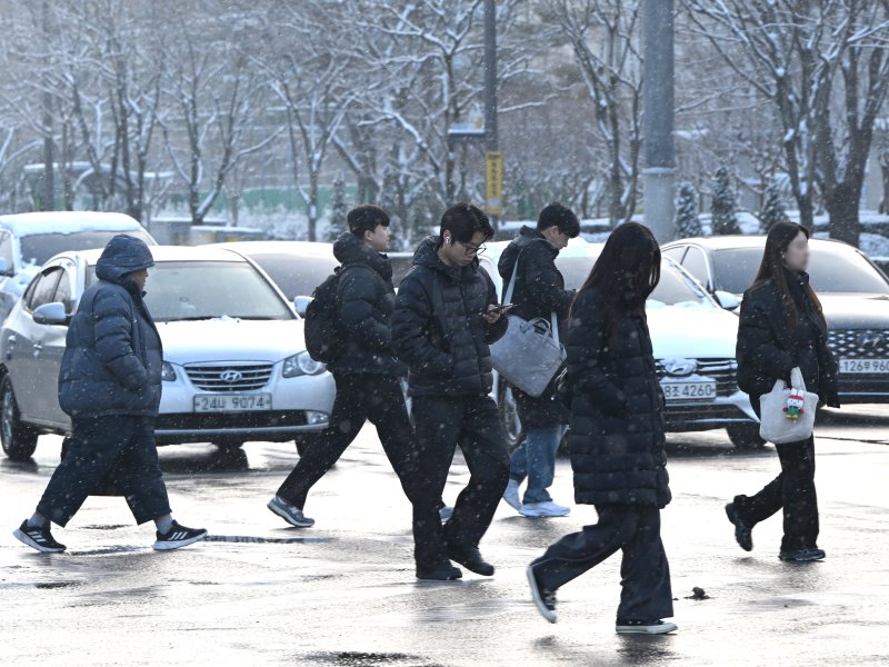 [광주=뉴시스] 이현행 기자= 밤사이 눈이 쌓인 2일 오전 광주 서구 치평동 광주시청 앞에서 출근길에 나선 시민들이 호주머니에 손을 넣고 길을 건너고 있다. 2026.02.02. lhh@newsis.com