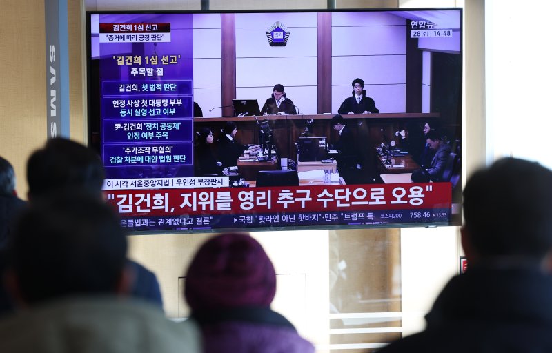 28일 오후 서울역 대합실에서 시민들이 김건희 여사의 자본시장법·정치자금법 위반, 특정범죄 가중처벌법상 알선수재 혐의 1심 선고 공판 생중계를 지켜보고 있다. 서울중앙지법 형사합의27부(부장판사 우인성)는 이날 알선수재 등 혐의로 기소된 김 여사에게 징역 1년 8개월을 선고했다. 압수된 그라프사 다이아몬드 목걸이의 몰수 및 1281만 원의 추징도 명했다. 자본시장법 위반과 정치자금법 위반 혐의에 대해서는 무죄를 선고했다. 2026.1.28/뉴스1 ⓒ News1 오대일 기자