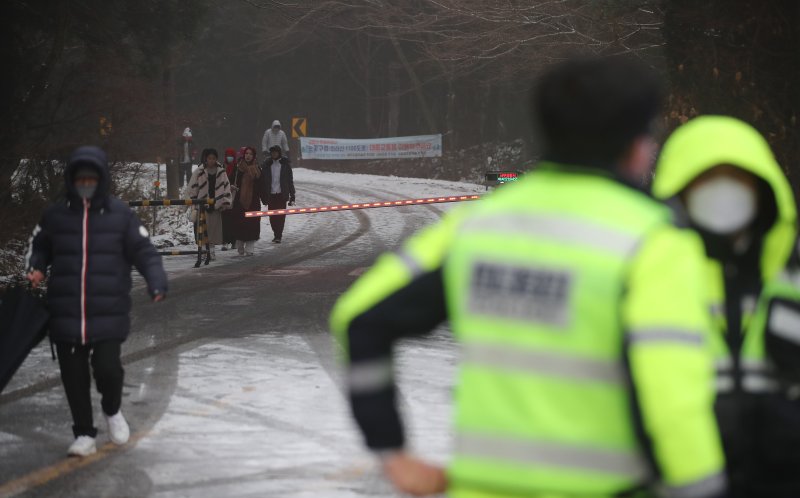 [제주=뉴시스] 우장호 기자 = 제주도 산지에 대설주의보가 내려진 2일 오전 제주 한라산을 통과하는 1100도로 입구인 제주시 어승생 삼거리에서 제주서부경찰서 소속 경찰관이 도로통제를 하고 있다. 2026.02.02. woo1223@newsis.com