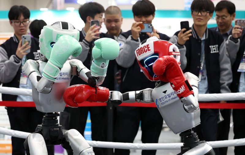 지난해 10월 23일 대구시 북구 엑스코에서 열린 미래혁신기술박람회(FIX 2025)에서 관람객들이 중국 로봇 기업 유니트리 로보틱스가 개발한 휴머노이드 로봇 'G1' 복싱 경기 시연을 보고 있다. 뉴시스