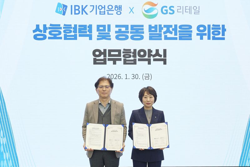 오정순 IBK기업은행 개인고객그룹장(오른쪽)과 오진석 GS리테일 플랫폼SU 부사장이 지난달 30일 서울 을지로 기업은행 본점에서 협약식을 마친 뒤 기념촬영을 하고 있다. IBK기업은행 제공