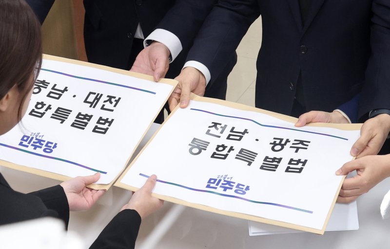 천준호 더불어민주당 원내수석부대표와 전용기 원내소통수석부대표, 백승아 원내대변인이 지난달 30일 서울 여의도 국회 의안과에 '충남·대전 통합특별법'과 '전남·광주 통합특별법'을 제출하고 있다. 뉴시스