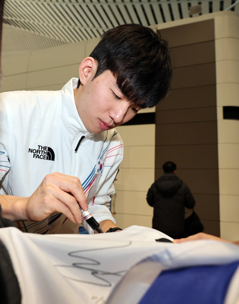 2026 밀라노·코르티나담페초 동계올림픽에 출전하는 대한민국 스피드스케이팅 대표팀의 정재원이 30일 오전 인천국제공항 제2터미널을 통해 이탈리아 밀라노로 출국 전 응원 온 팬이 가져온 태극기에 사인을 하고 있다. 2026.1.30/뉴스1 ⓒ News1 김진환 기자