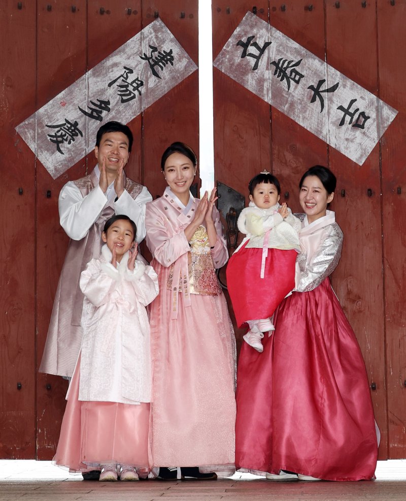 [서울=뉴시스] 조성우 기자 = 절기상 입춘인 4일 오전 서울 중구 남산골한옥마을에서 열린 입춘첩 붙이기 시연 행사에 참여한 1990년생 경오년 말띠인 박민지(오른쪽) 씨와 박은혜 씨가 가족과 함께 '입춘대길·건양다경'이라고 적힌 입춘첩을 붙인 뒤 포즈를 취하고 있다. 2026.02.04. xconfind@newsis.com