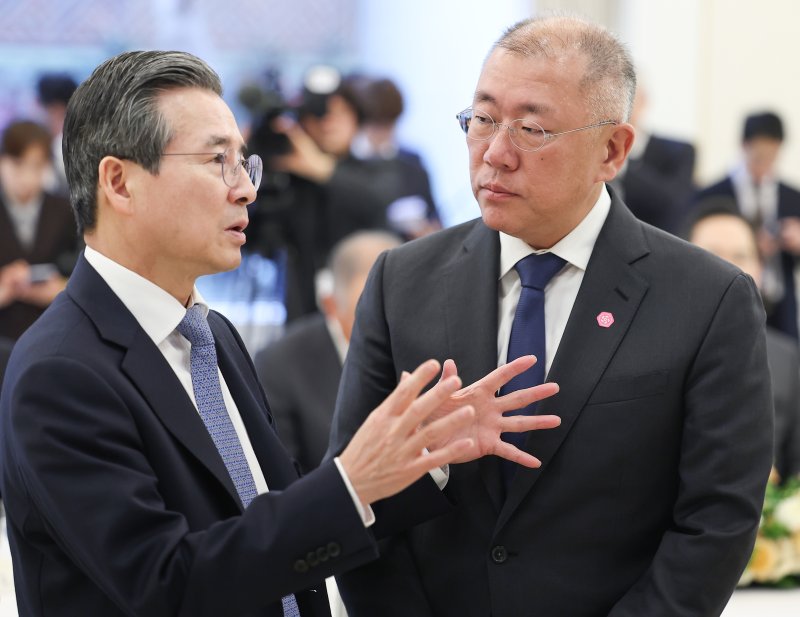 김용범 정책실장(왼쪽)과 정의선 현대차그룹 회장이 회의에 앞서 각각 대화를 나누고 있다. 연합뉴스·뉴스1