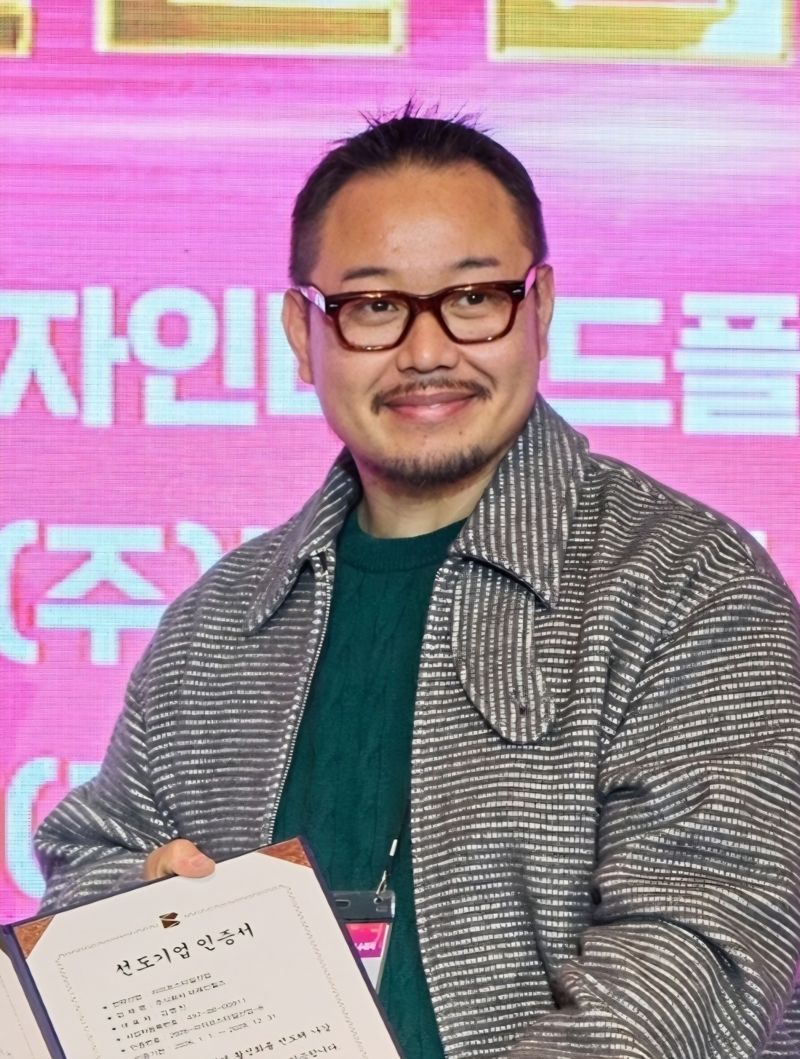 '2026~2028년 부산디자인 선도기업' 인증서를 들고 포즈를 취하고 있는 김명진 대표. 브레인힐스 제공