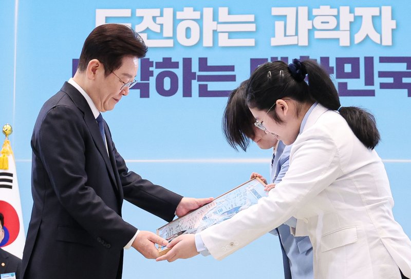 [서울=뉴시스] 고범준 기자 = 이재명 대통령이 5일 청와대에서 열린 대통령과학장학생·올림피아드 대표단 친수 및 간담회(미래 과학자와의 대화)에서 국제과학올림피아드 대표단에게 우리나라 도약을 이끌 미래 과학자로서 다짐을 담은 기념액자 전달을 받고 있다. 2026.02.05. bjko@newsis.com