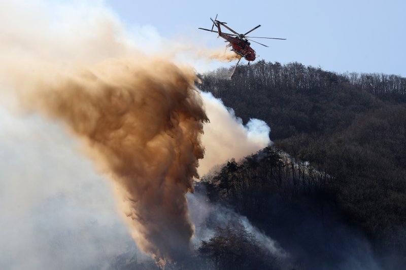 8일 오전 경북 경주시 문무대왕면 안동리 야산에서 산불 진화에 투입된 헬기가 진화작업을 벌이고 있다. 뉴스1