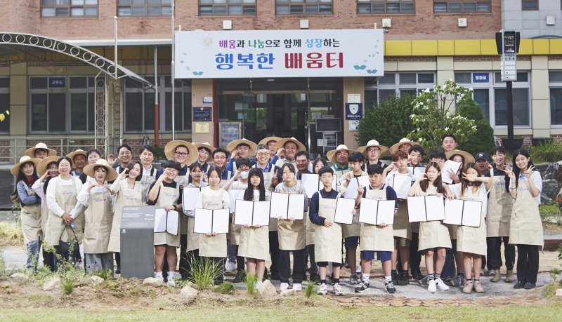 현대글로비스 임직원 봉사단이 지난해 5월 충남 당진 당산초등학교에 학교 생태숲 3호를 조성한 뒤 학생, 교직원들과 기념촬영을 하고 있다.