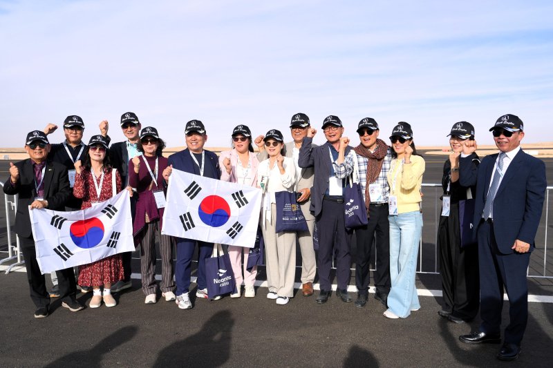 사우디아라비아 수도 리야드에서 열린 2026 국제방산전시회(WDS)에서 공군 특수비행팀 블랙이글스의 에어쇼를 관람한 뒤 태극기를 펼치며 응원을 보내고 있다. 한국방위산업진흥회