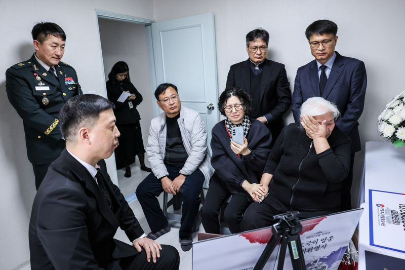 김성환 국유단장 직무대리(육군 중령)가 행사에 참석한 유가족에게 고인에 대해 설명하는 가운데 고인의 여동생 최길자 씨(오른쪽 첫 번째)가 눈물을 닦고 있다. 국방부 제공