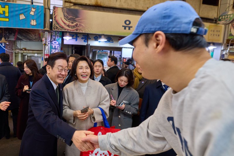 이재명 대통령과 김혜경 여사가 지난 11일 충북 충주시 무학시장을 방문해 상인과 인사하고 있다. 청와대 제공