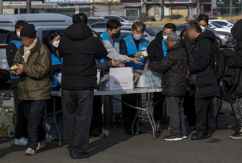 [서울=뉴시스] 정병혁 기자 = 염영남 뉴시스 대표이사 사장과 임직원들로 구성된 뉴시스 봉사단이 11일 서울 용산구 서울역 광장에서 노숙인 설맞이 떡 나눔 지원 봉사활동을 하고 있다. 2026.02.11. jhope@newsis.com