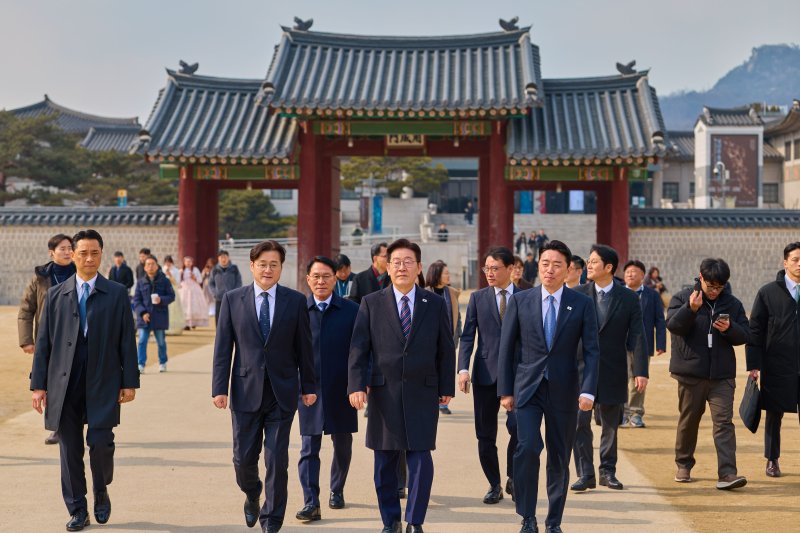 이재명 대통령이 12일 서울 종로구 경복궁에서 강훈식 비서실장, 홍익표 정무수석 등 참모진과 오찬을 마친 뒤 산책을 하고 있다. 청와대 제공