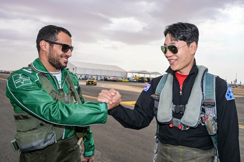 공군 특수비행팀 블랙이글스는 지난 8일부터 12일까지(현지 시간) 사우디아라비아에서 열린 세계 방위산업 전시회(WDS 2026)에 참가해 에어쇼를 선보였다. 공군이 중동지역 방산전시회에 참가하는 것은 이번이 처음이다. 사진은 지난 7일 진행된 블랙이글스-사우디 호크스(Saudi Hawks) 지상교류 행사에서 블랙이글스 4번기 조종사 정희문 대위와 사우디 호크스 7번기 조종사 압둘아지즈 라시디 소령이 손을 맞잡으며 우정을 다지고 있다. 공군 제공