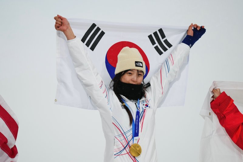 최가온이 12일(현지시간) 이탈리아 리비뇨 스노파크에서 열린 2026 밀라노·코르티나담페초 동계올림픽 스노보드 여자 하프파이프 결승에서 금메달을 획득한 뒤 시상대에서 태극기를 들어 올리고 있다. /사진=뉴시스