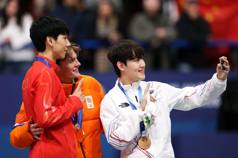 13일(한국시간) 이탈리아 밀라노 아이스스케이팅 아레나에서 열린 쇼트트랙 남자 1,000m 시상식에서 금메달 옌스 판트 바우트(네덜란드), 은메달 쑨룽(중국), 동메달 임종언(대한민국) 선수가 갤럭시 Z 플립7 올림픽 에디션으로 빅토리 셀피를 찍고 있다. 삼성전자 제공