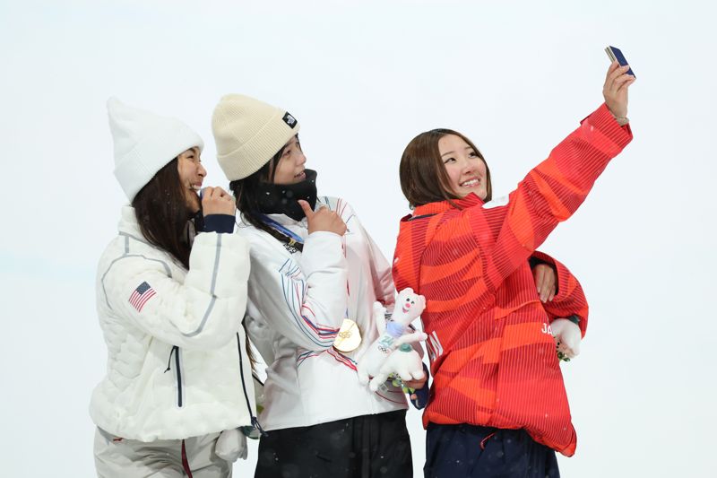 13일(한국시간) 이탈리아 리비뇨 스노파크에서 열린 2026 밀라노·코르티나담페초 동계 올림픽 스키 스노보드 여자 하프파이프 시상식에서 금메달 최가온(대한민국), 은메달 클로이 김(미국), 동메달 요노 미츠키(일본) 선수가 갤럭시 Z 플립7 올림픽 에디션으로 빅토리 셀피를 찍고 있다. 삼성전자 제공