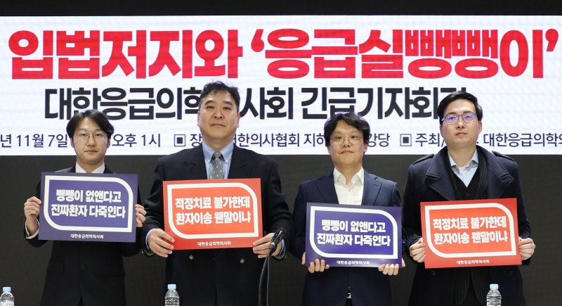 [서울=뉴시스] 김진아 기자 = 7일 서울 용산구 대한의사협회에서 열린 119강제수용 입법저지와 '응급실뺑뺑이' 해결을 위한 대한응급의학의사회 긴급 기자회견에서 이형민 대한응급의학의사회 회장 등이 손팻말을 들고 있다. 2025.11.07. bluesoda@newsis.com