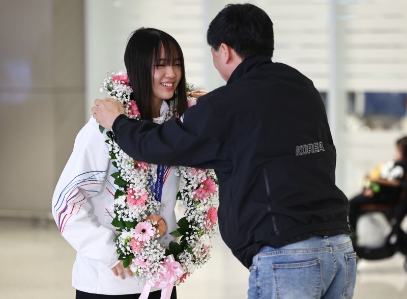 2026 밀라노·코르티나담페초 동계올림픽 스노보드 빅에어에서 동메달을 차지한 유승은이 21일 인천공항2터미널을 통해 귀국해 꽃목걸이를 받고 있다. 2026.2.21 ⓒ 뉴스1 김도우 기자