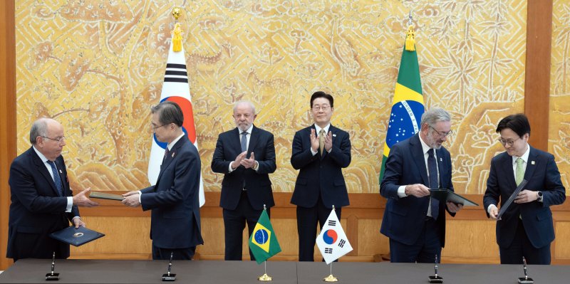 조현 외교부 장관과 김정관 산업통상부 장관, 마우루 비에이라 브라질 외교부 장관, 마르시우 엘리아스 호쟈 개발산업상공서비스부 차관이 23일 청와대에서 이재명 대통령과 브라질 루이스 이나시우 룰라 다 시우바 대통령이 임석한 가운데 통상·생산 통합 협약을 체결한 뒤 악수하고 있다. 뉴시스