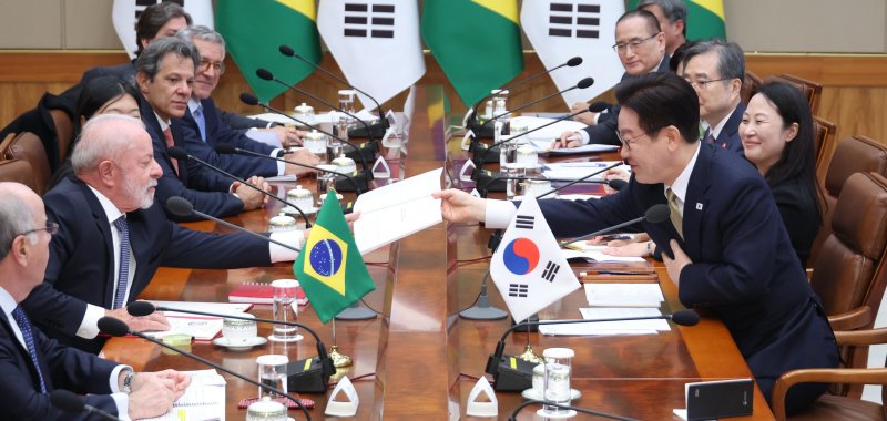 이재명 대통령이 23일 청와대에서 열린 한-브라질 확대 정상회담에서 루이스 이나시우 룰라 다 시우바 대통령이 요청한 책자에 사인 후 전달하고 있다. 2026.2.23 ⓒ 뉴스1 이재명 기자